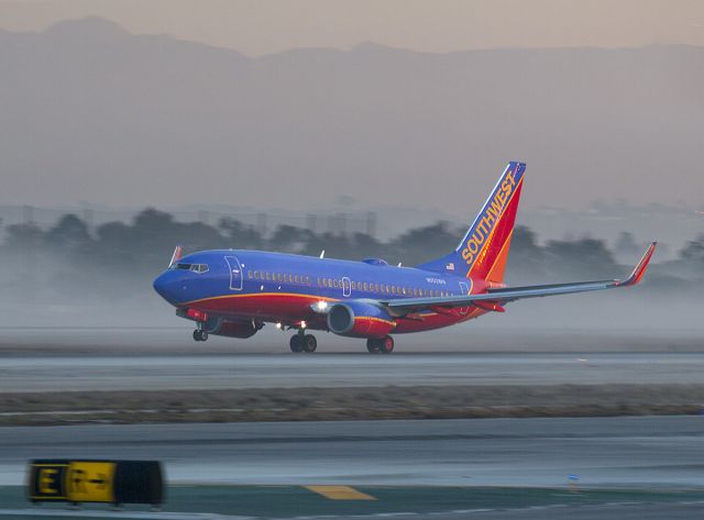 Boeing 737-700 (N553WN) - Taking off through early morning ground fog, LAX, Los Angeles, California.