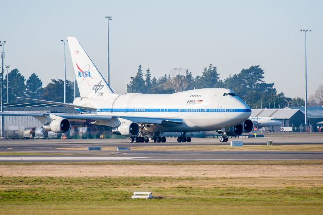 BOEING 747SP (N747NA) - SOFIA departing the "Deep Freeze" apron for a long flight northward to Palmdale CA via Honolulu Hawaii. Turning left onto Taxiway Alpha to taxi down to the end of Runway 02.