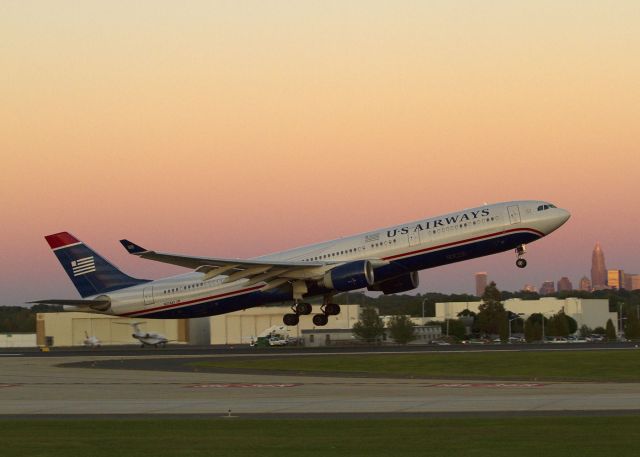 Airbus A330-300 (N274AY) - A big Airbus 330-300 takes off from Charlotte, North Carolina just after sunset. It is a non-stop flight (AWE 732) to London-Gatwick. Check its progress on "Flight Aware, Track by Flight Number." Downtown Charlotte is visible in the distance.