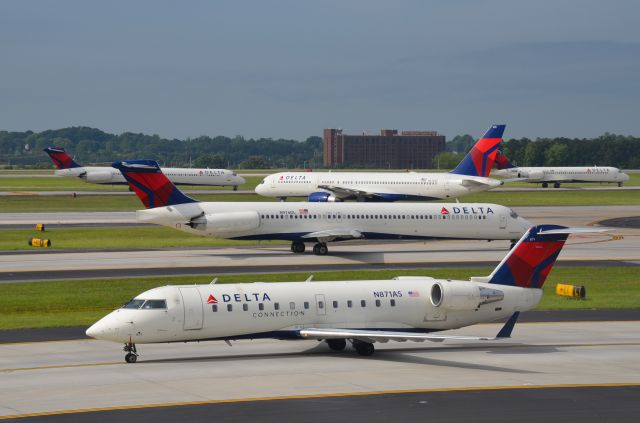 Canadair Regional Jet CRJ-200 (N871AS) - Delta Connection on Txwy L with lots of Delta action in the background.  Viewed from the south parking lot at ATLs domestic terminal. 