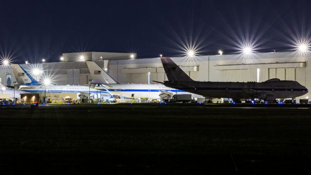 — — - Night time shot of 2 E4B's and a VC25A sitting out on the ramp at the Boeing facility at Kelly field.