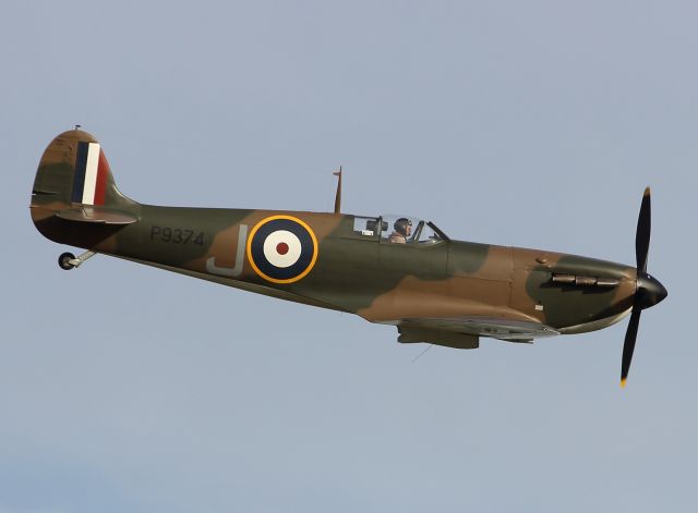 — — - A Spitfire performs a Flypast at Duxford Air Museum during the 2012 September Show.