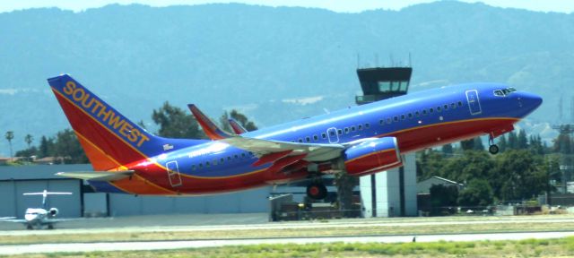 Boeing 737-700 (N414WN) - Departure from 30R as viewed from inside Terminal B - Gate 25 following Grand Opening Ceremonies for "The New Airport" .   SJC Tower on oposite side of aircraft