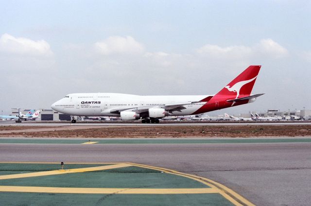 Boeing 747-400 (VH-OJE) - KLAX - March 1990 shows then new 747-438 of QANTAS arriving from Sydney on 25L and rolling to the exit to cross 25R following the Alaska 727 in the left side of the photo.