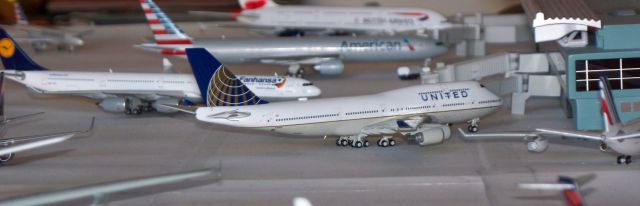 Boeing 747-200 (N180UA) - United Airlines 744 just arrived at the gate from Shanghai. Lufthansa A346 pulling into the gate from Frankfurt. American 773 boarding for a flight out to London, and British Airways A388 boarding for a flight out to London.