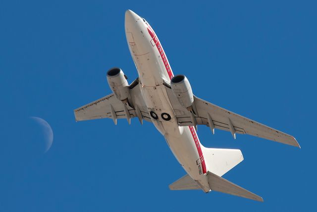 BOEING 737-600 (N319BD) - One of the companys six 737-66Ns departing. Was lucky enough to include the moon in this shot.