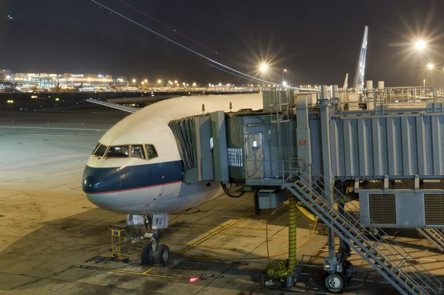 BOEING 777-300 (B-KPJ) - 26th October, 2015 ... My ride back to San Francisco waits at the gate as passengers board for the journey across the Pacific Ocean. Background shows sister-ship taking off from runway 25R for the flight to LAX ... and the outline of iconic hills of Hong Kongs Chek Lap Kok Island.