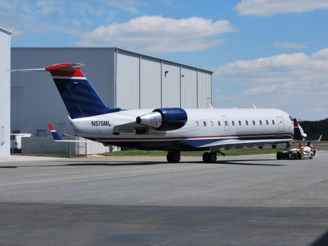 Canadair Regional Jet CRJ-200 (N570ML) - STEWART-HAAS RACING LLC being towed back to the hangar at KJQF. The newest aircraft to the SH fleet, still with US Airways Express colors - 3/27/13  UPDATE: Re-registered as N141SH