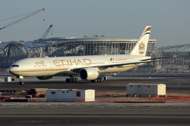 BOEING 777-300 (A6-ETL) - Early morning arrival with the new terminal under construction in the background