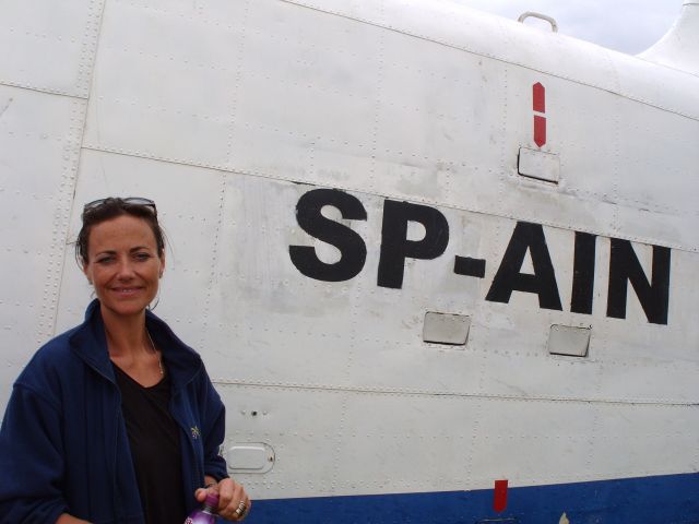 SP-AIN — - EGBV is Silverstone, England. Type is Antonov An-2. Photo taken on 18AUG2009. c/n 1G210-27. Alexandra Mayorga, the Spanish team manager, poses in front of the AN-2 prior to commencement of the World Aerobatic Championships (WAC) 2009. The AN-2 was used by the Spanish team as a support aircraft during the tournament. Operated by Unlimited Aerobatics - Grupo Albión.