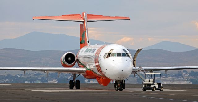 McDonnell Douglas MD-87 (N295EA) - The pilots of Erickson's MD-87 Air Tanker (N295EA) have no choice but to sit in the cockpit and wait to depart Reno Stead Airport because RTS is closed to all but air race aircraft in this click taken during the 2019 National Championship Air Races last month.br /Had an emergency situation been declared somewhere in the western United States that had required the immediate dispatch of Tanker 105, the qualification races being conducted would have been suspended long enough for N295EA and the three other Air Tankers sitting at RTS to depart. But with no such declaration, four air tankers waited until racing action ended for the day. This tanker, along with the other three, was gone within ten minutes after RTS was reopened at 4:50 PM.