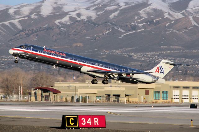 McDonnell Douglas MD-83 (N973TW) - The sun has just come up over the Virginia Range mountains east of the airport (behind the photographer) as this MD-83 lifts off from Reno Tahoe International and passes the airport Fire Department facilities on its early morning departure for Dallas.