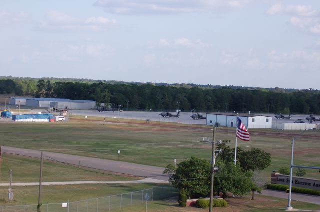 — — - AH-64Ds parked at Lone Star, and the Lone Star Executive airport entrance.