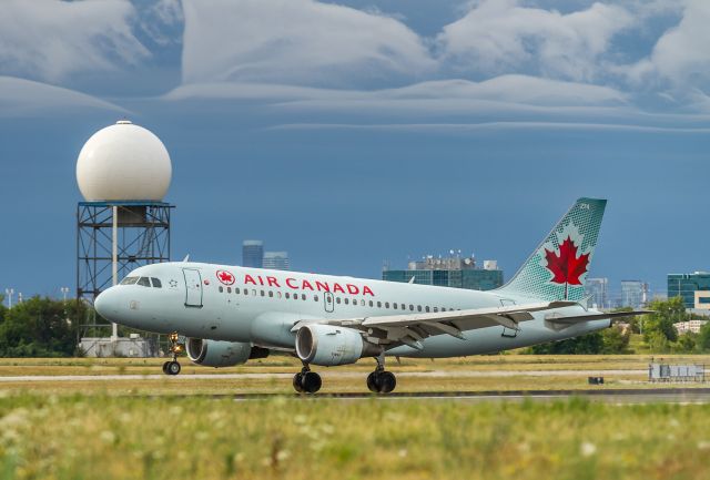 Airbus A319 (C-GBHM) - Some cool clouds in the distance as this AC baby bus touches down on runway 05 at YYZ