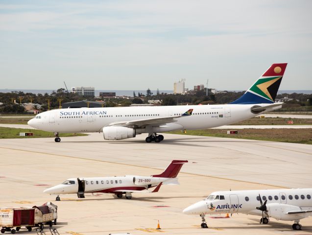 Airbus A330-200 (ZS-SXZ) - A very rare and unusual visitor to our very small local airport. This past weekend saw an influx of over 6000 athletes to our city (read : town) for the Iron Man Competition. On Tuesday 4 September our National Carrier had to replace the usual 11:00 am flight (SA405) of either an A319 or A320, with this wide-body A330-243. Not only for the large number of International athletes heading back to Johannesburg, but also for the Cargo. Besides the usual "baggage", there were also a few hundred bicycles that needed to be loaded up. Flight SA405 (SA410 return) operated the A332 on both Tues &amp; Wed to accommodate all the extra passengers and their unusual cargo. With a runway length of less than 6,700 foot it becomes a tight fit for this big bird. The apron is too narrow to park "normally" and therefore she had to park at an angle. Being at sea level, and with a typical wind blowing, besides the parking space, our little airport can handle it. The last time a aircraft of comparable size visited our airport was in 2010 for the Soccer World Cup.