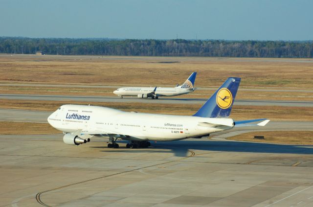 Boeing 747-400 (D-ABTF) - DLH 747 taxiing for takeoff while a 737 lands on 26L.