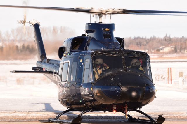 Bell 412 (C-FYZQ) - This Bell 412 came thru Yorkton for a training flight. The crew are seen here working on the preflight just before departure. 