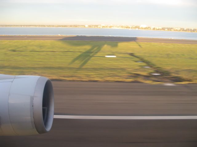 Boeing 747-200 — - About to touch down 06:35h just after sunrise at Kingsford Smith. 747 shadow looks just like a wasp! (Old image taken 29 March 2007.)