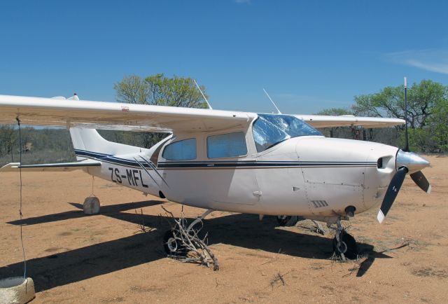 Cessna Centurion (ZS-MFL) - At Ingwelala, South Africa. Thorn bushes around the wheels to prevent hyaenas chewing them up.