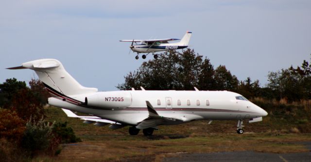 Canadair Challenger 350 (N730QS) - Taxiing for departure is this 2016 Bombardier Challenger 350 while the 1977 Cessna 152 is about to land in the Autumn of 2021.