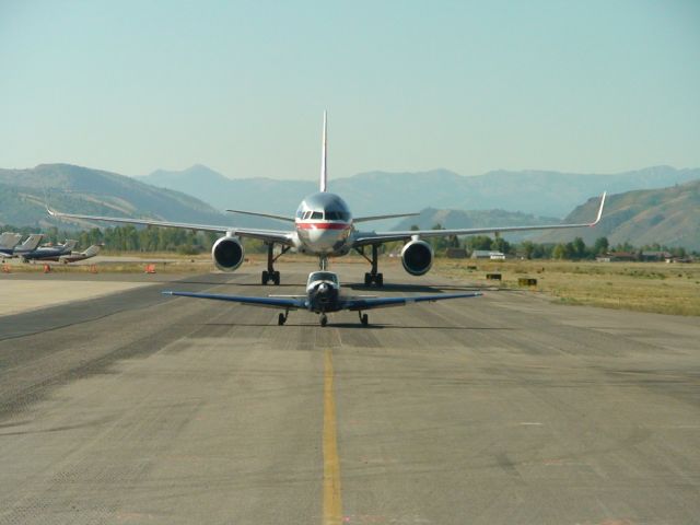 Boeing 757-200 — - AA 757 taxing to terminal after landing in Jackson Hole, WY. Has to wait for the "little guy" to move.