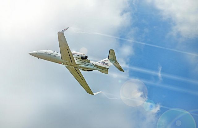 Learjet 31 (N929JH) - Heavy rain, humidity, and sudden drop in temperature as well as the sun just peaking out of the clouds made for an interesting capture as the learjet pulled up hard after leaving the runway.  