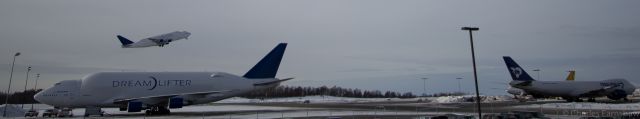 Boeing Dreamlifter (N747BC) - A Dreamlifter (N747BC) takes flight as another one (N780BA) is getting ready for its next flight from Anchorage International Airport. 3-4-2013