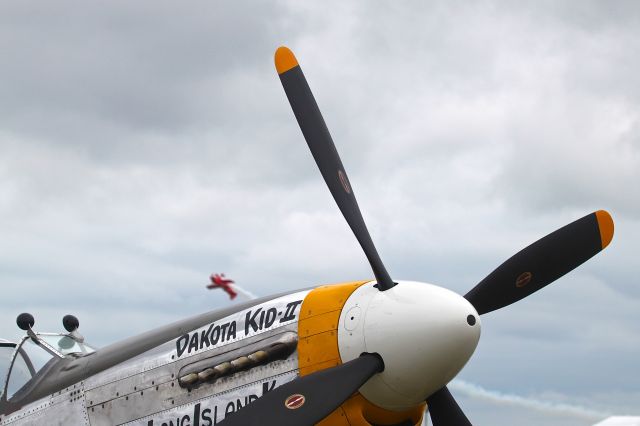 North American P-51 Mustang (N151HR) - P-51 parked at Oshkosh while Sean Tucker performs in the background 