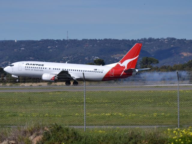 BOEING 737-400 (VH-TJZ) - A Qantas old girl "smoking" on landing on runway 05.