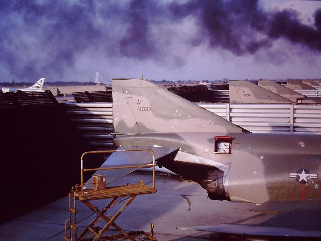 AFR41037 — - TAN SON NHUT AIR BASE, SAIGON, VIETNAM APRIL 1966 ATTACK ON THE base and the RF-4C SQUADRON.  ATTACK WAS AT NIGHT and this photo was late the next afternoon and there was something still burning (Not an RF4C).  Those doors open were the photo flash ejection system for night photography which ejected cartridges to light up the night.  The spots on 037 were shrapnel damage from mortars.