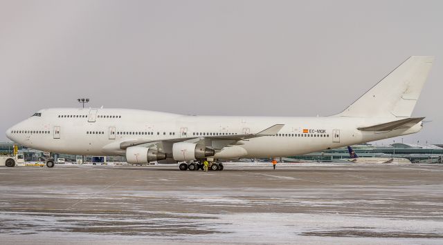 Boeing 747-400 (EC-MQK) - Catch of the day and a great way to start off the New Year spotting! This Wamos 747 subbed for a Westjet 767 that went technical in London Gatwick the night before. Here shes being pushed back on the cargo ramp. The tug got stuck on a patch of ice and the plane sat idle for a long time before they got her moving again! Those poor flagmen, it was FREEZING cold! Operated as Westjet 9901 ferry flight back to Barajas Intl in Madrid. She ferried home empty! 