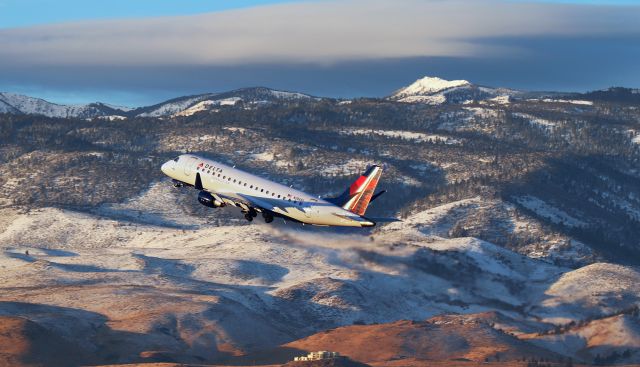 EMBRAER 175 (long wing) (N286SY) - A SkyWest (Delta Connection) Embraer is on the climb from 16R and tucking the wheels in the wells in this sunrise-hour shot.