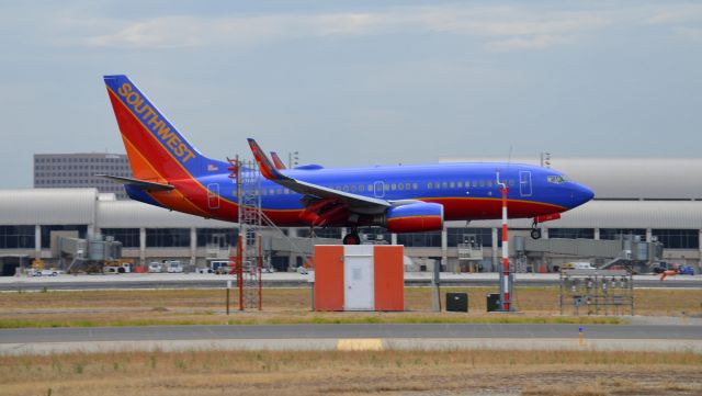 Boeing 737-700 (N250WN) - N250WN is captured just before it touches down at JWA. I had a series of 5 shots of this aircraft and I chose this one because it took an ordinary Southwest 737 scene and changed it just a little bit having the equipment in front of it.