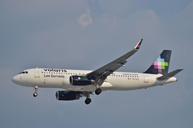 Airbus A320 (XA-VLO) - Airbus A320-233 XA-VLO MSN 6969 of Volaris  named "Los Serrano" is on short final to runway 05R at Mexico City International Airport (06/2019).