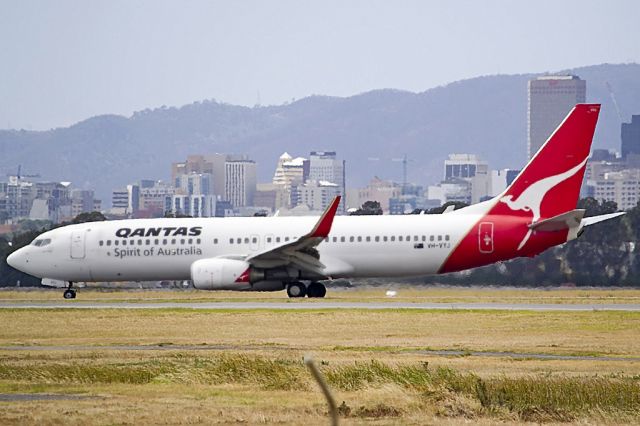 Boeing 737-800 (VH-VYJ) - Heading for Terminal 1 after landing on runway 23, on the last day of the Australian summer. Thursday 28th February 2013. The Adelaide city skyline can be seen in the gloomy background.