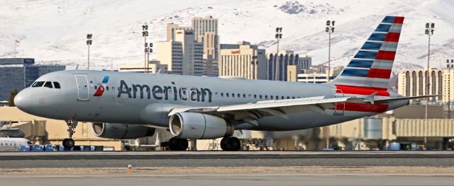 Airbus A320 (N647AW) - The mains are down and rolling and the nose wheel tire is a heartbeat away from touching down on 16R in this closeup capture of AAL's N647AW, an A320, landing at Reno Tahoe International with a portion of the downtown Reno skyline in the background.  The thrust reversers have been activated and are just starting to open.