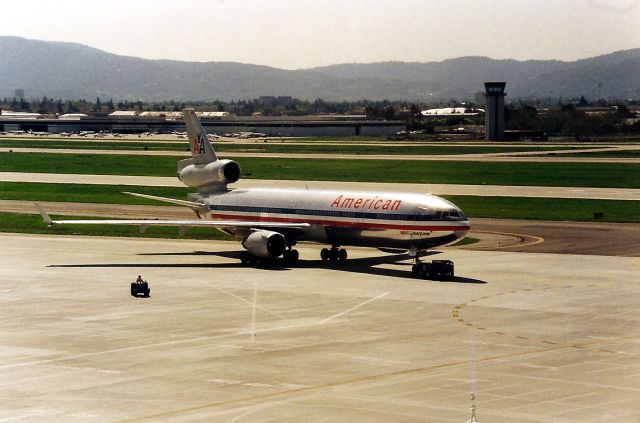 Boeing MD-11 (N1751K) - KSJC- back in the early 1990 s American flew the MD-11 SJC-NRT ( using the DC-10-30 as the Inaugural jet ) and back with a connecting 757 to BOS-SJC. At times, there were 2 MD-11 s at SJC frequently - and I never knew why. This MD-11 being towed back to the gate from the old Customs building at SJC - a real cut on the citizens of SJC back then. It was embarassing. Then the brilliant ones at SJC decided to build a Custom Inspection building and connect it to the new Terminal A south end and forever wrecking a perfect viewing area on the top floor of the parking garage. SJC went down hill fast after that and airline photographers were screwed from that day on - not to mention the inane SJPD Airport Police driving all of the way up to the top 6th floor just to ask us  what are you doing while standing in front of them with a camera. Photos like this were quickly eliminated when the new Customs building was done.