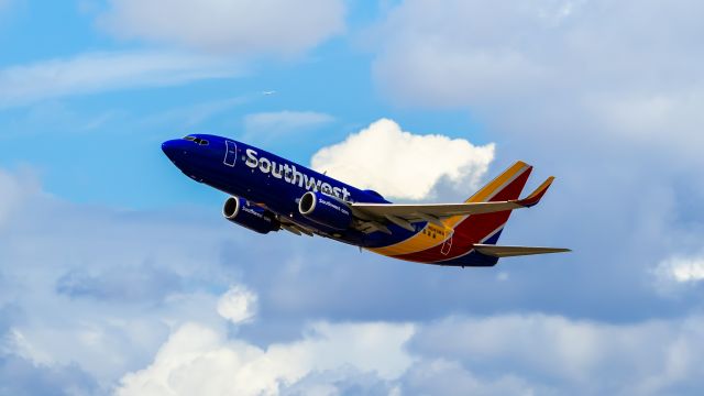 N243WN — - Southwest Airlines 737-700 taking off from PHX on 8/20/22 with a departing American Airlines A321 neo in the background. Taken with a Canon 850D and Rokinon 135mm f/2 manual focus lens.
