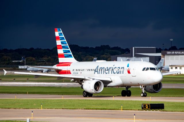 Airbus A319 (N700UW) - American Airlines A319 taxiing to Runway 1L on a dark day with the sun barely peeking out of the clouds onto the plane.