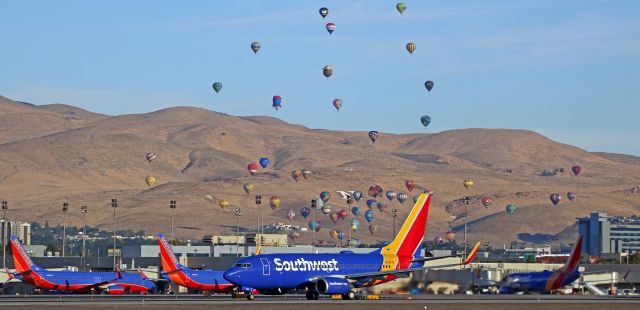 Boeing 737-700 (N7877H) - This click illustrates why the month of September is the absolute greatest month for every northern Nevada area photographer who enjoys taking pictures of activity occurring in the sky. The dawn-hour Mass Ascension of hot air balloons during the annual Great Reno hot air balloon event, captured in this photo taken last year, heralds the start of two weeks of fantastic airborne activity in Reno and northern Nevada. And in two days, it all begins again. The 2019 Great Reno Balloon Race will be held next weekend, the 2019 Tailhook Convention will be held here again as it always is, and the National Championship Air Races will begin just two days after the hot air balloon event and the Tailhook Convention conclude. The balloon race means the sky will be full of hot air balloons, the Tailhook Convention means there will be US Navy aircraft at RNO, and the Air Races means military statics, military flybys, air show performances, and high speed air racing. And, this year, STOL drag racing too. Charge up those camera batteries, clean those lens, and have plenty of digital cards: September has arrived. 