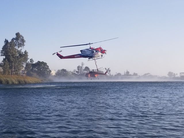 Bell VH-1 (N800DM) - City of San Diego Fire Rescue Department Copter 1 at Lake Murray, San Diego, California USA prepiring to load for drops on a vegetation fire. S64 N217AC is loading in the background.