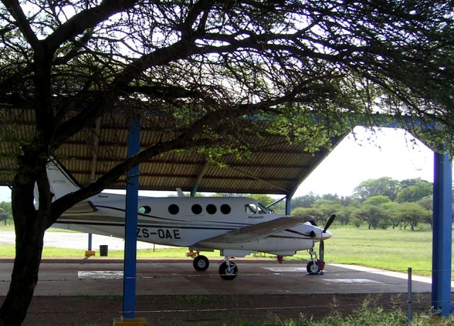 Beechcraft King Air 90 (ZS-OAE) - At the Winterveld mine, South Africa. Drive thru hangar.