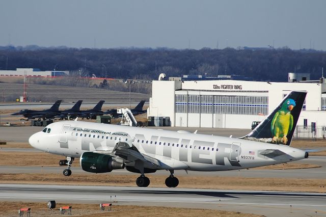 Airbus A319 (N937FR) - "Carmen" The Blue Crowned Conure just about to touch down on runway 23 in Des Moines from Denver with the 132nd Fighter Wing building in the background.br /br /Now flies for Brussels Airlines as OO-SSB.