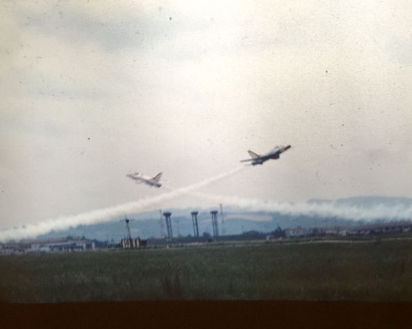 — — - Two USAF Thunderbirds F-100 Super Sabres performing at Rimini Miramare Airport (Italy) during the spring or summer of 1967. Photo is from a color slide taken by my father while he was stationed at Rimini Airbase with the Detachment 2700 7232nd Munitions Maintenance Group and with the Italian 5A Aerobrigata.  Image clarity is not perfect but still wanted to share this historic photograph.