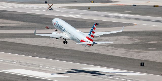 Boeing 737-800 (N301NW) - In this 11 AM-hour shot, American's N301NW has just rotated and is on the climb over the final 1000 feet of runway 16 Left. Because runway 16R-34L was closed (as can be seen in the background of this photo), a very large percentage of arriving and departing traffic was passing almost directly beneath my spotting position in the center of the airport.