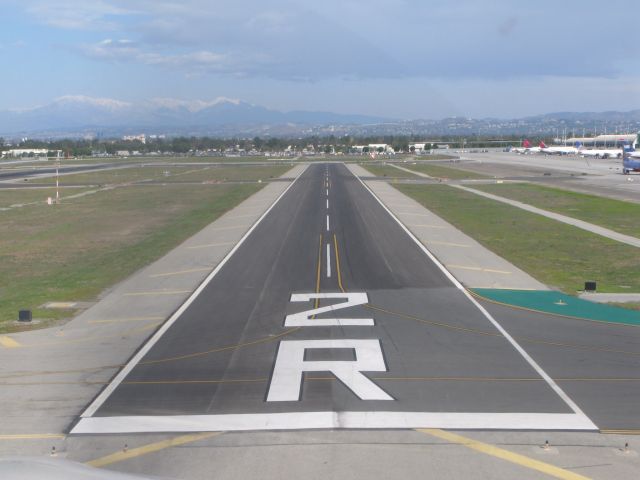 — — - "Hitting the numbers".   Runway 2R at John Wayne International, Santa Anna, California.   Photo taken from right seat of SR22.