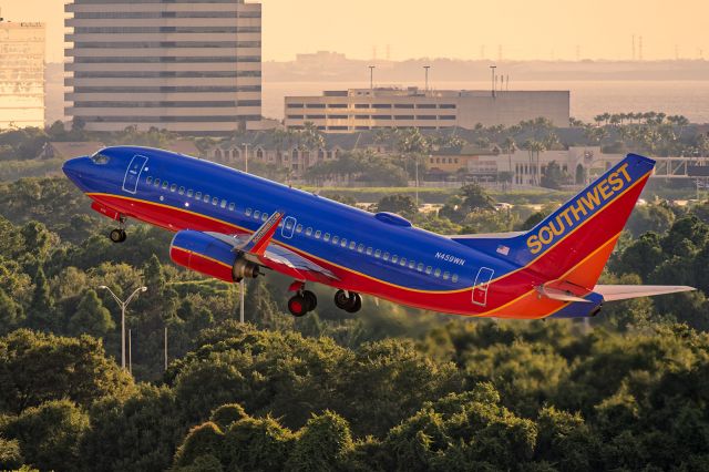 Boeing 737-700 (N459WN) - 8/12/2015. Early evening departure to KBHM. Sunlight was reflected back on the aircraft by light concrete taxiway and the glass windows on the terminals.