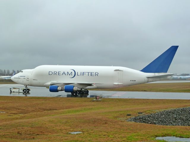 Boeing 747-400 (N718BA) - 1-28-2011 Dreamlifter 747-407 LCF, N718BA is being pushed from the Boeing ramp east of the main runway at Paint Field in Everett, Washington to the back side of the Future of Flight Aviation Center in Mukilteo, Washington.  The Flight Center often puts on shows for visiting subcontractors who come to Mukilteo / Everett to take the Boeing Tour. The Dreamlifter, the worlds largest plane in cargo volume, is always a major attraction. ||| Photo taken from the Flight Center / Paine Field fence line by Bruce McKinnon