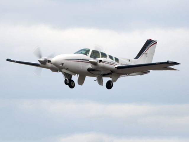 Beechcraft Baron (58) (N7237X) - Take off runway 26. Retraction of the mechanically operated landing gear.