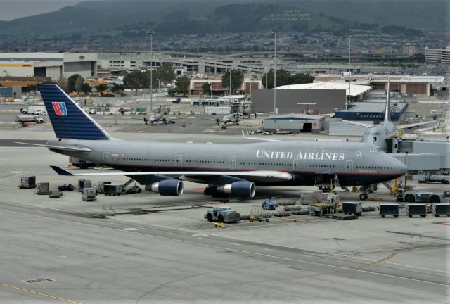 Boeing 747-400 (N127UA) - KSFO Feb 14, 2005 looking at Intl Terminal G gates - long before the A380s showed up at San Francisco. This jet Cn 28813 Ln: 1221 flew it's entire airline service with United- now stored 2017. UAL 747-400s were a dime a dozen at SFO but always worth a photo! Side note, if you look along the right side of the photo you'll see a parking structure with the circular ramps - that has been extended to public long term parking now with added floors that jut out west offering views of the 28LR arrival/departure runways and great for PM photography, or just pay the fee and sit and watch from your car. To the left of that parking structure, is the Best Western Grosvenor Hotel, where I help run the SFO Airline Collectible Show(FB). We've been at this Hotel for almost 10-15 years I can't remember exactly - overall 32 years total near SFO...but is very popular w/show attendees as so close to SFO..many hours at the show hunting airline collectibles, and still the rest of the day for photos and airport viewing. But of course the September 26, 2020 we had to cancel for Covid 19 issues. Next Show is March 2021,,,we'll see how fast the vaccine is found after the election depending on who wins...Funny how small the other 747-400 looks facing the camera off to the right gate.